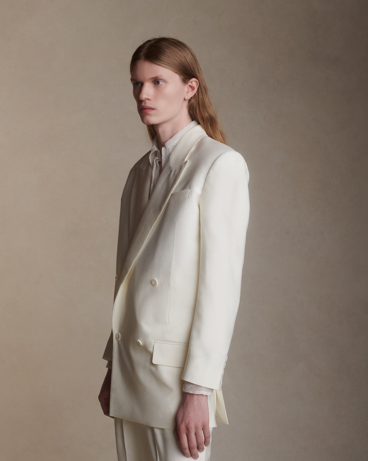 Matte silk wool double breasted jacket with luminous silk wool peaked lapel. Two welt pockets at front and double vented back. Ivory shell buttons at center front and sleeve opening.
