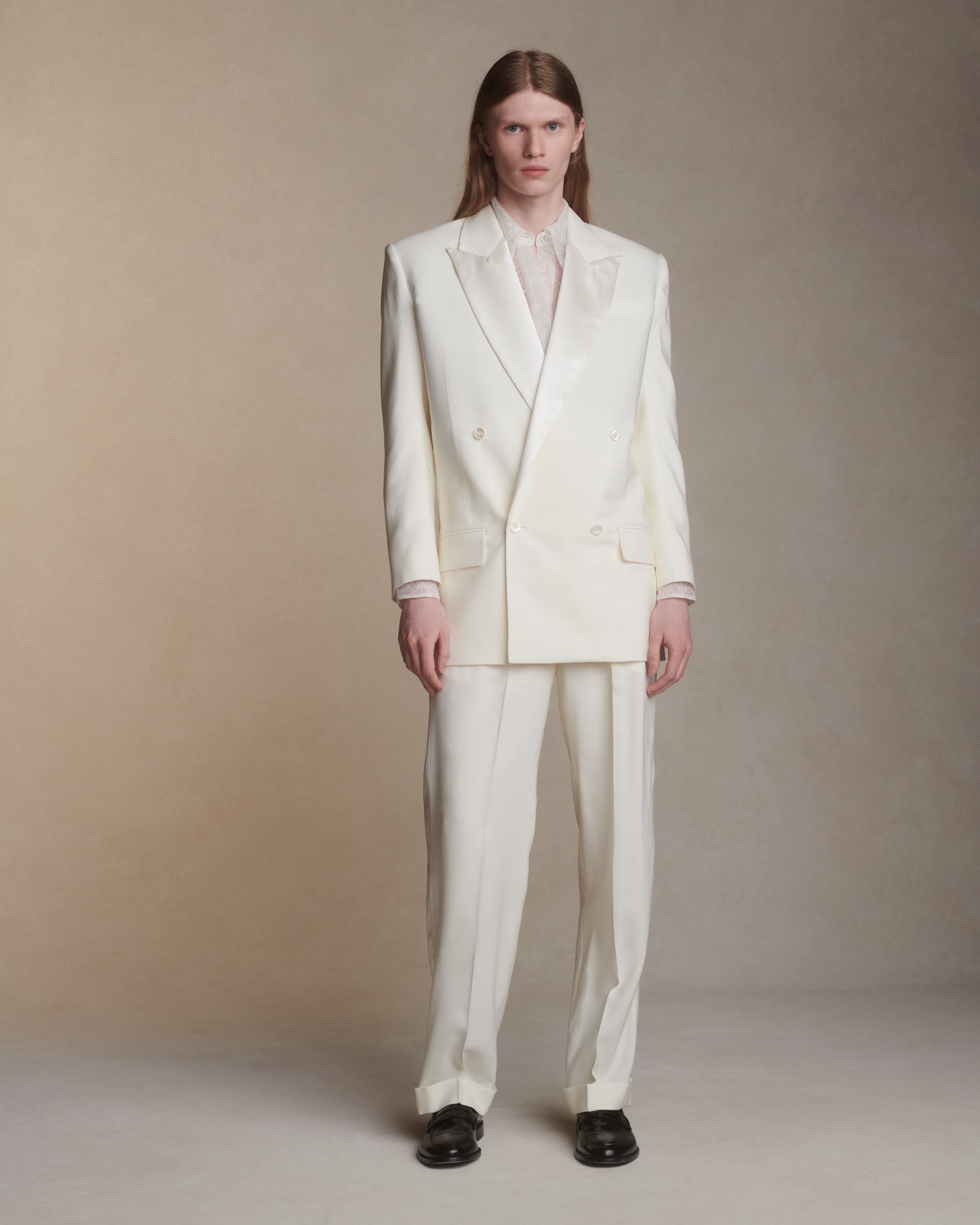 Matte silk wool double breasted jacket with luminous silk wool peaked lapel. Two welt pockets at front and double vented back. Ivory shell buttons at center front and sleeve opening.