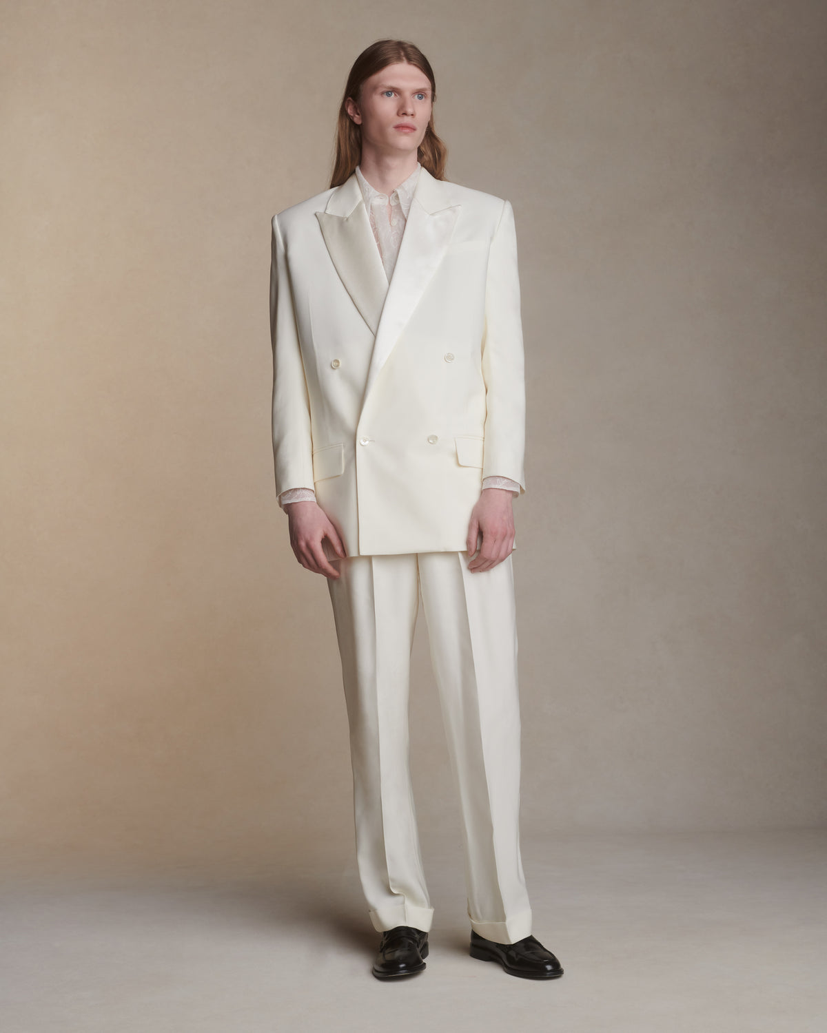 Matte silk wool double breasted jacket with luminous silk wool peaked lapel. Two welt pockets at front and double vented back. Ivory shell buttons at center front and sleeve opening.