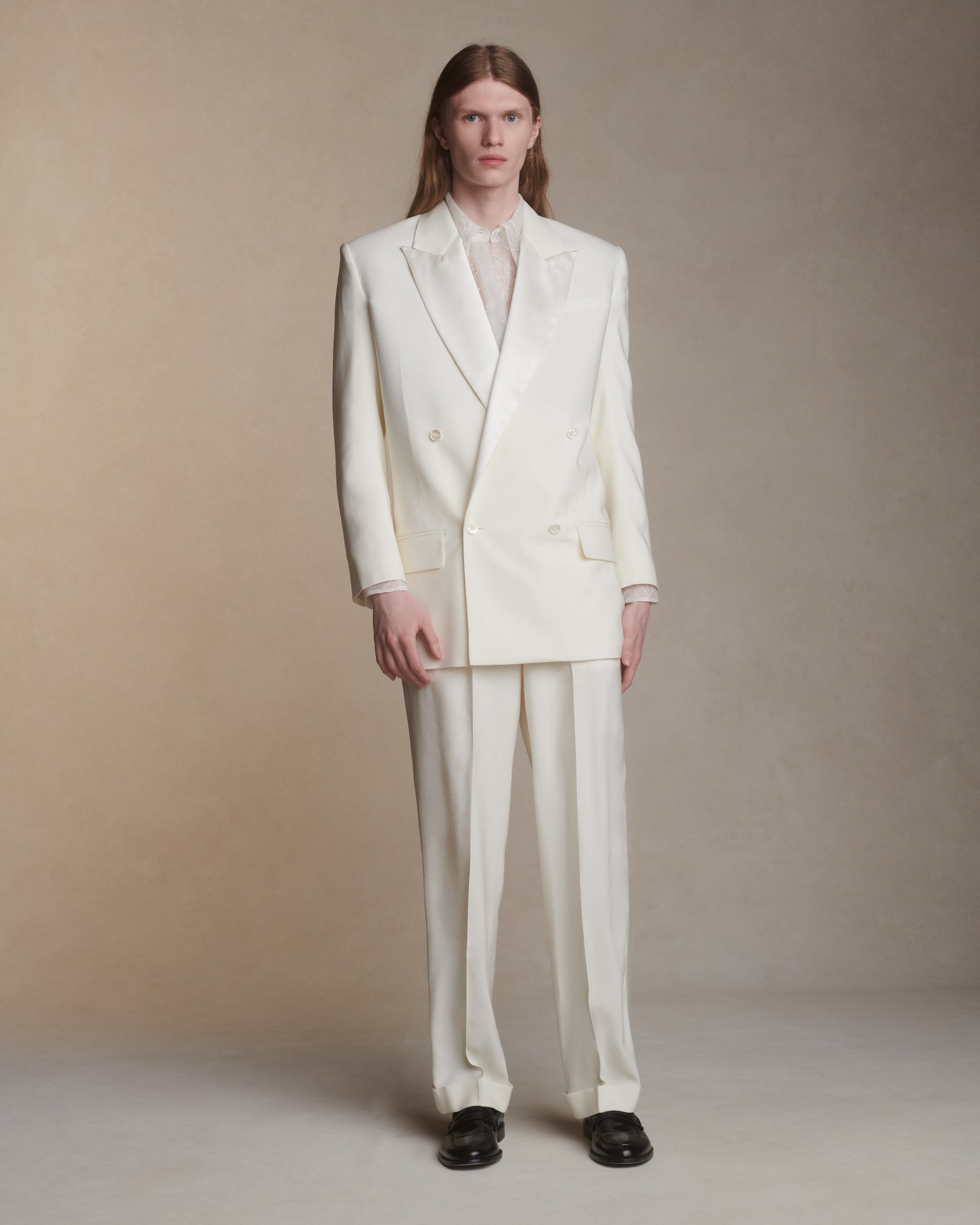 Matte silk wool double breasted jacket with luminous silk wool peaked lapel. Two welt pockets at front and double vented back. Ivory shell buttons at center front and sleeve opening.