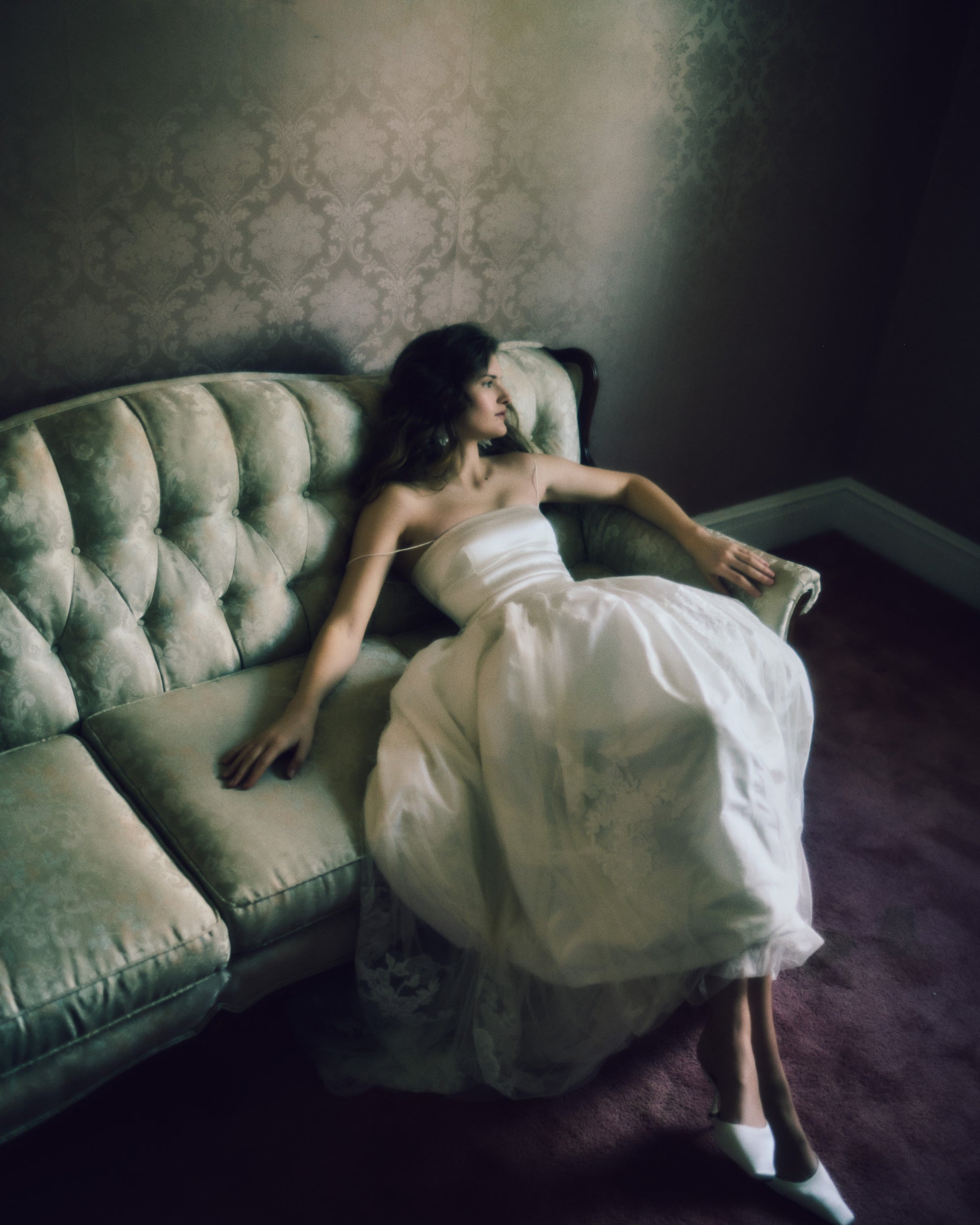 Fitted silk wool drop waist camisole bodice graduating into an airy silk taffeta bubble skirt. Soft tulle skirt overlay is adorned with hand cut chantilly and lace appliques. Straight neckline with spaghetti straps. Internal waist belt and center back zip closure.