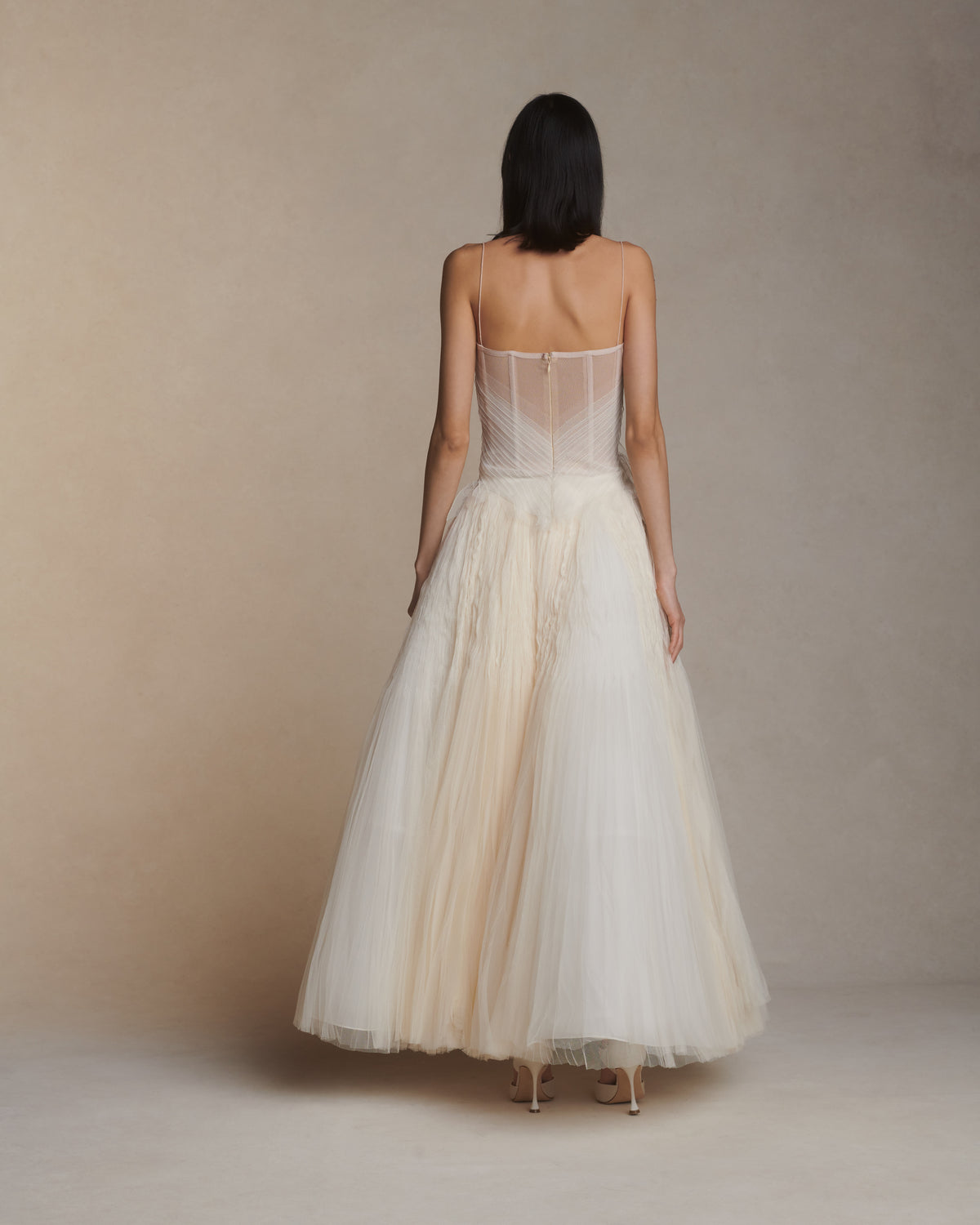 Camisole bustier top suspended by delicate spaghetti straps. Picot tulle ribbons criss cross across bodice, falling organically over hem. Boned corset revealed at center back. Center back zip closure.Styled with Theo SkirtStyled with Georgia Skirt