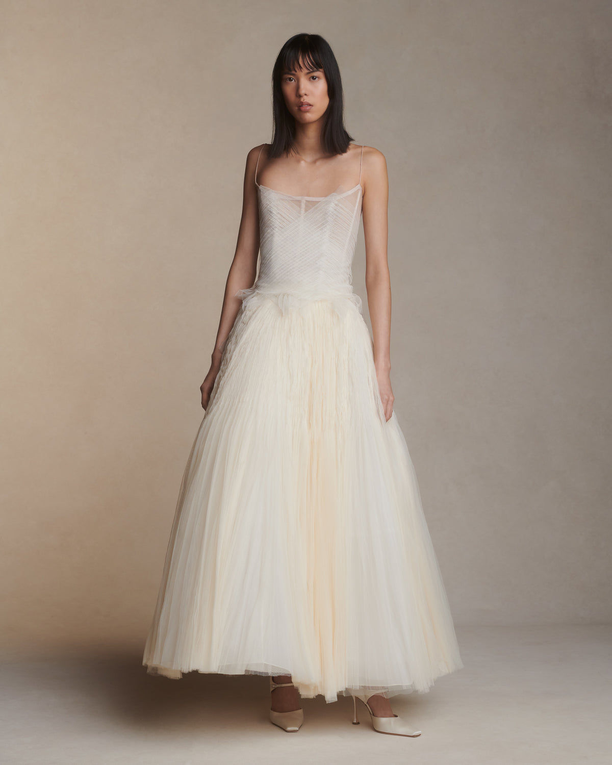 Camisole bustier top suspended by delicate spaghetti straps. Picot tulle ribbons criss cross across bodice, falling organically over hem. Boned corset revealed at center back. Center back zip closure.Styled with Theo SkirtStyled with Georgia Skirt