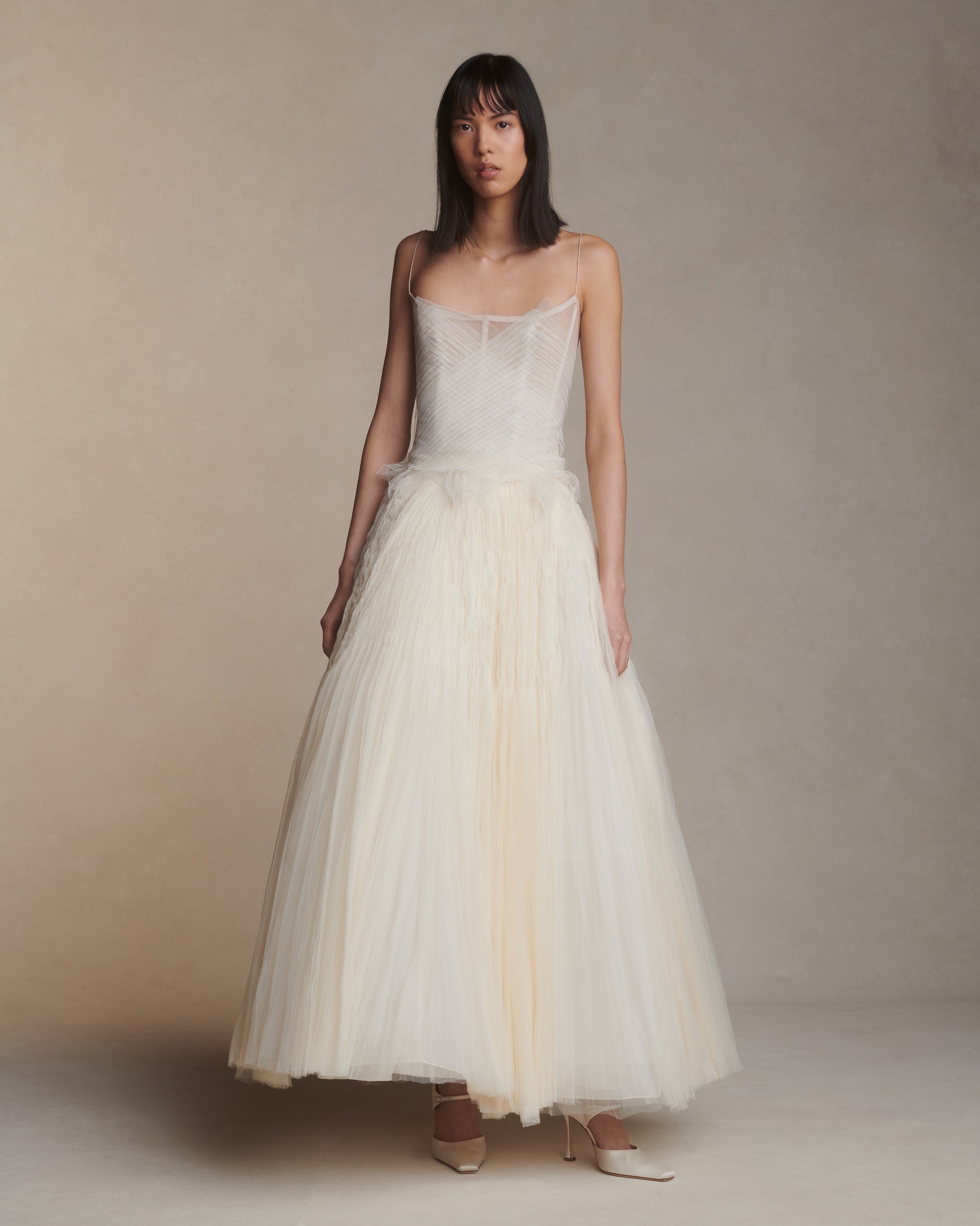 Camisole bustier top suspended by delicate spaghetti straps. Picot tulle ribbons criss cross across bodice, falling organically over hem. Boned corset revealed at center back. Center back zip closure.Styled with Theo SkirtStyled with Georgia Skirt