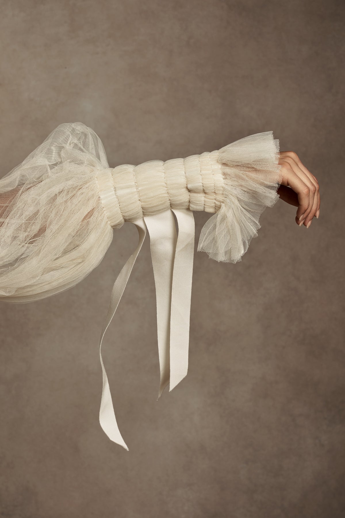 Silk Wool Satin gown with train. Pleated, delicate Tulle sleeves are gathered with Grosgrain detail.Styled with Flaired Baroque Pearl Drop Earrings 
