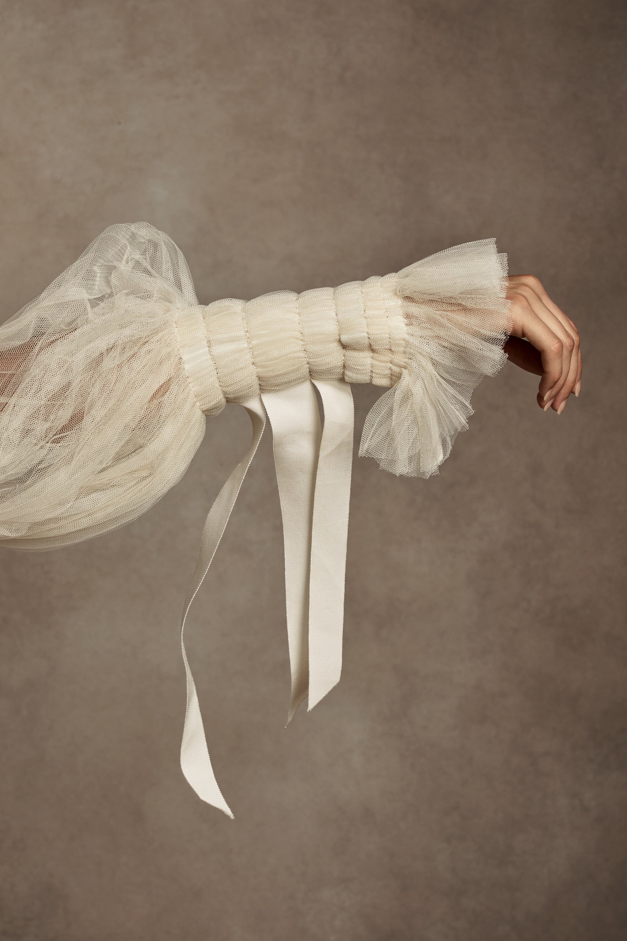 Silk Wool Satin gown with train. Pleated, delicate Tulle sleeves are gathered with Grosgrain detail.Styled with Flaired Baroque Pearl Drop Earrings 