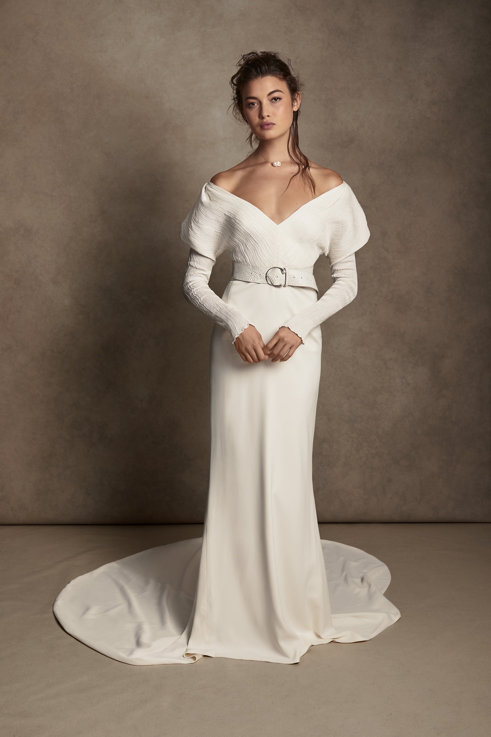 Off-shoulder gown with mini-pleated Georgette draped sleeves, and Grosgrain waist detail. Smooth faced Cady skirt, with circular train.Styled with Charlotte Skirt, Python Belt with Pearl Buckle and Flaired Baroque Pearl Drop Earrings.