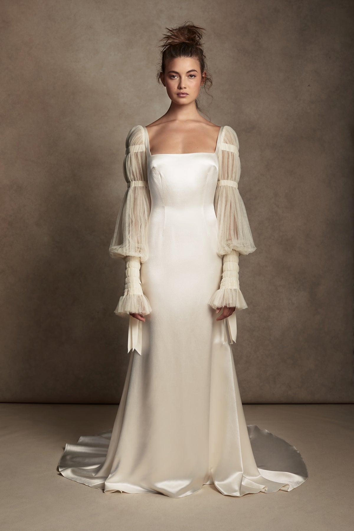 Silk Wool Satin gown with train. Pleated, delicate Tulle sleeves are gathered with Grosgrain detail.Styled with Flaired Baroque Pearl Drop Earrings 