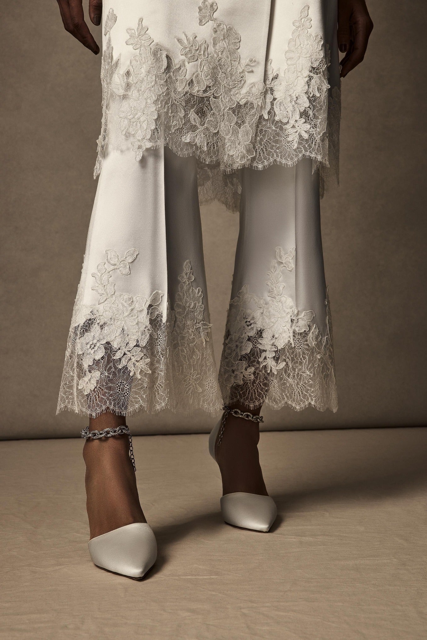 Silk wool and lace cropped flare pant. Hand cut appliqués ornamenting chantilly lace at hem. Clean front with side zip close.