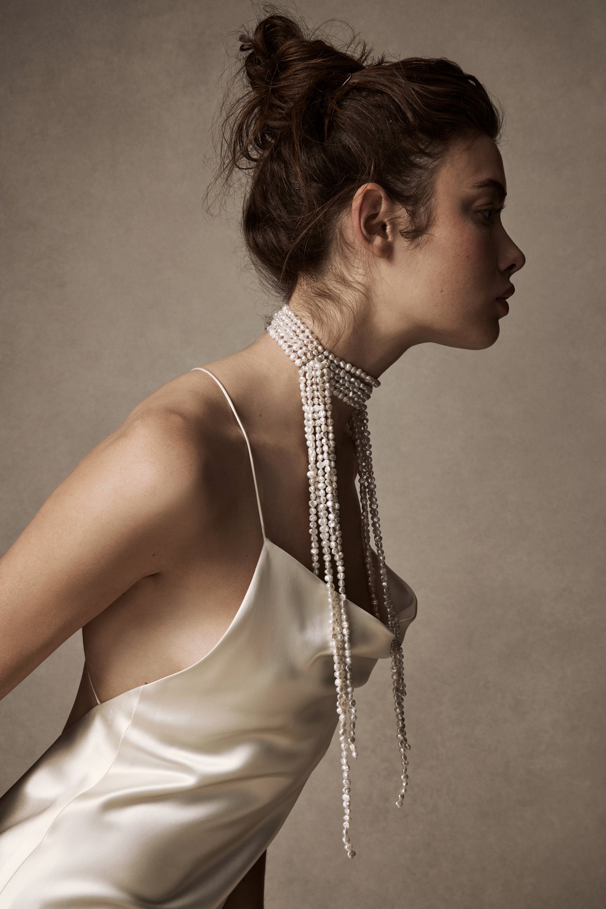 Hand knotted baroque pearls cascade from a 5 strand pearl choker secured with a silver slide lock closure at back