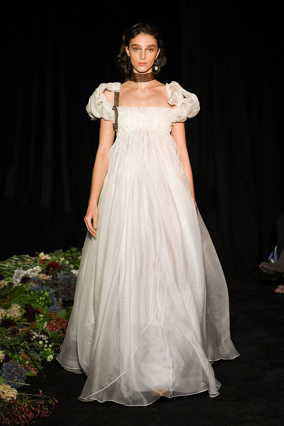 Darted and hand twisted organza ballgown with wave lace underlay. Puffed, tacked cap sleeve framing squared, empire neckline. Soft internal corset free of boning and wires with center back zipper. Nude georgette mini lining with can can and horsehair for shape and structure. 