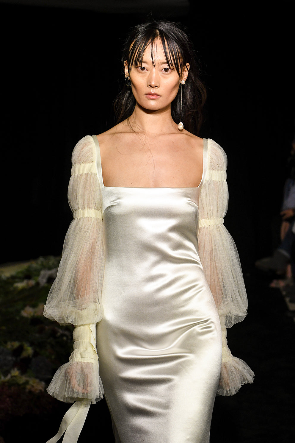 Silk Wool Satin gown with train. Pleated, delicate Tulle sleeves are gathered with Grosgrain detail.Styled with Flaired Baroque Pearl Drop Earrings 