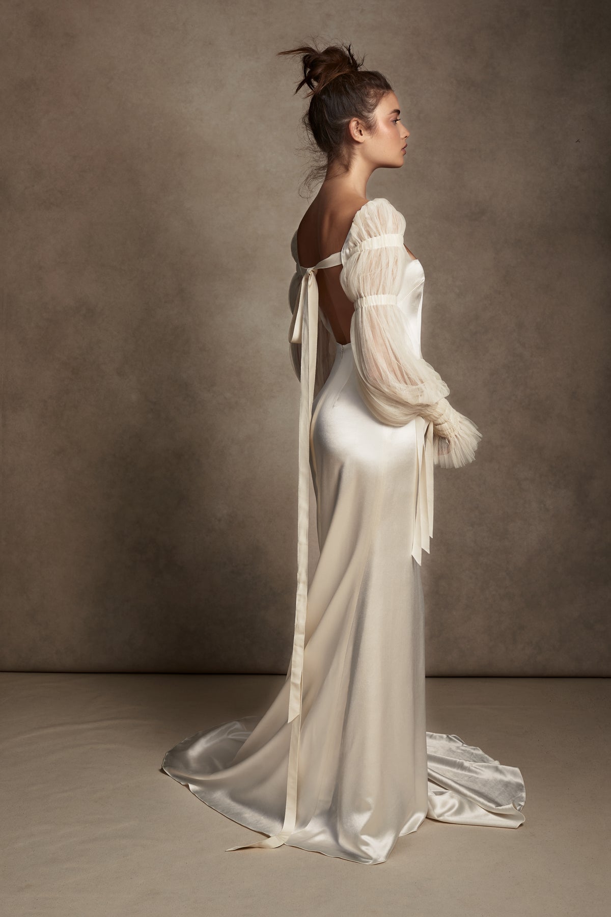 Silk Wool Satin gown with train. Pleated, delicate Tulle sleeves are gathered with Grosgrain detail.Styled with Flaired Baroque Pearl Drop Earrings 