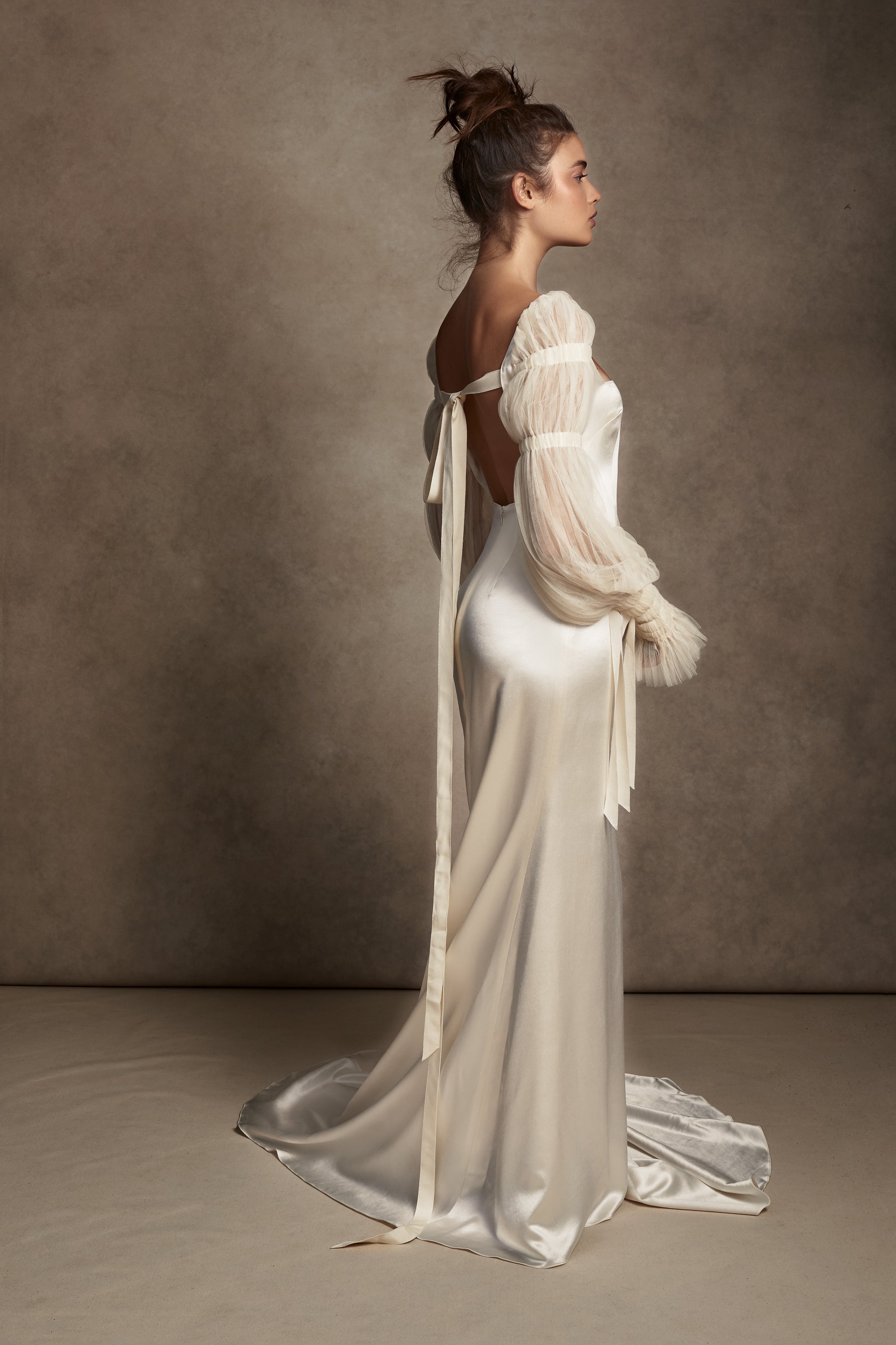 Silk Wool Satin gown with train. Pleated, delicate Tulle sleeves are gathered with Grosgrain detail.Styled with Flaired Baroque Pearl Drop Earrings 