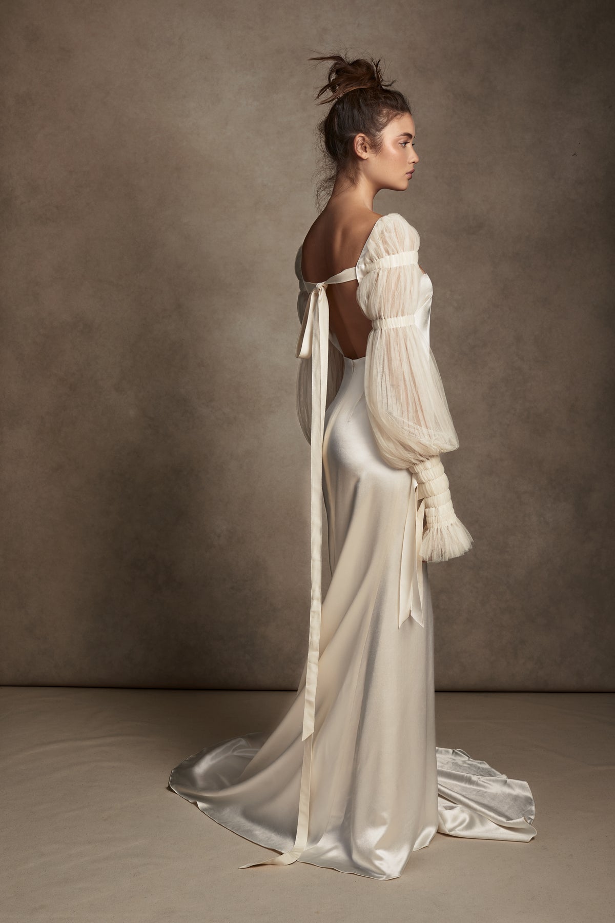 Silk Wool Satin gown with train. Pleated, delicate Tulle sleeves are gathered with Grosgrain detail.Styled with Flaired Baroque Pearl Drop Earrings 