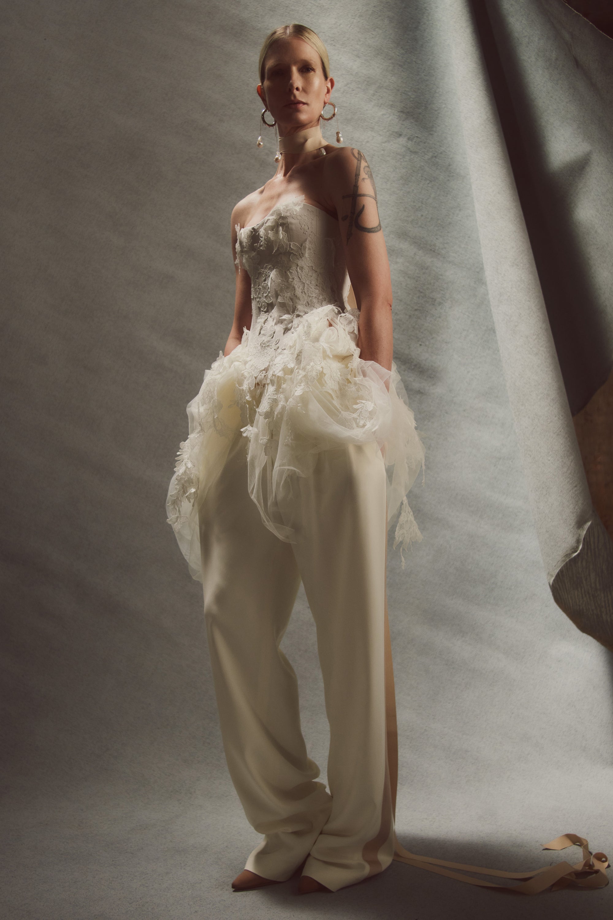Satin twill bound, chantilly and corded lace applique bustier with draped tulle accent at hips. Back zip with hook and eye closure for security and structure.﻿
