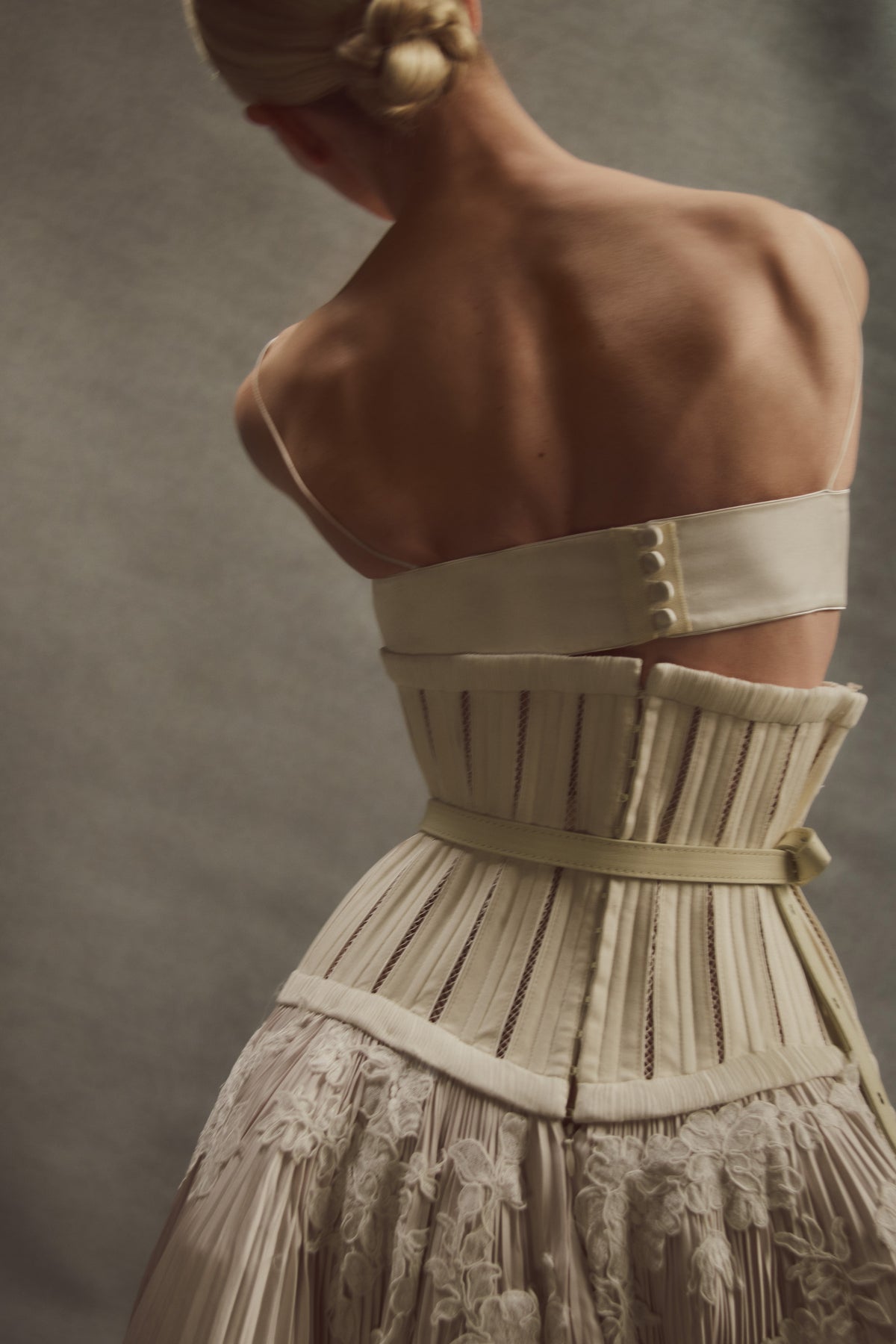 Bra: Fully structured, draped satin twill front with hand cut, hand applied corded lace with internal cups, grosgrain and four button loop closure at center back.  Skirt: Full corset with georgette trim and satin piping at seams attached to umbrella pleated skirt accented with hand cut corded lace. Hook and eye closure down center back, zipper at skirt layered over internal grosgrain waistband with three hook and bar positions. Skirt lined in organza and can can ruffle for interior construction and shaping.  