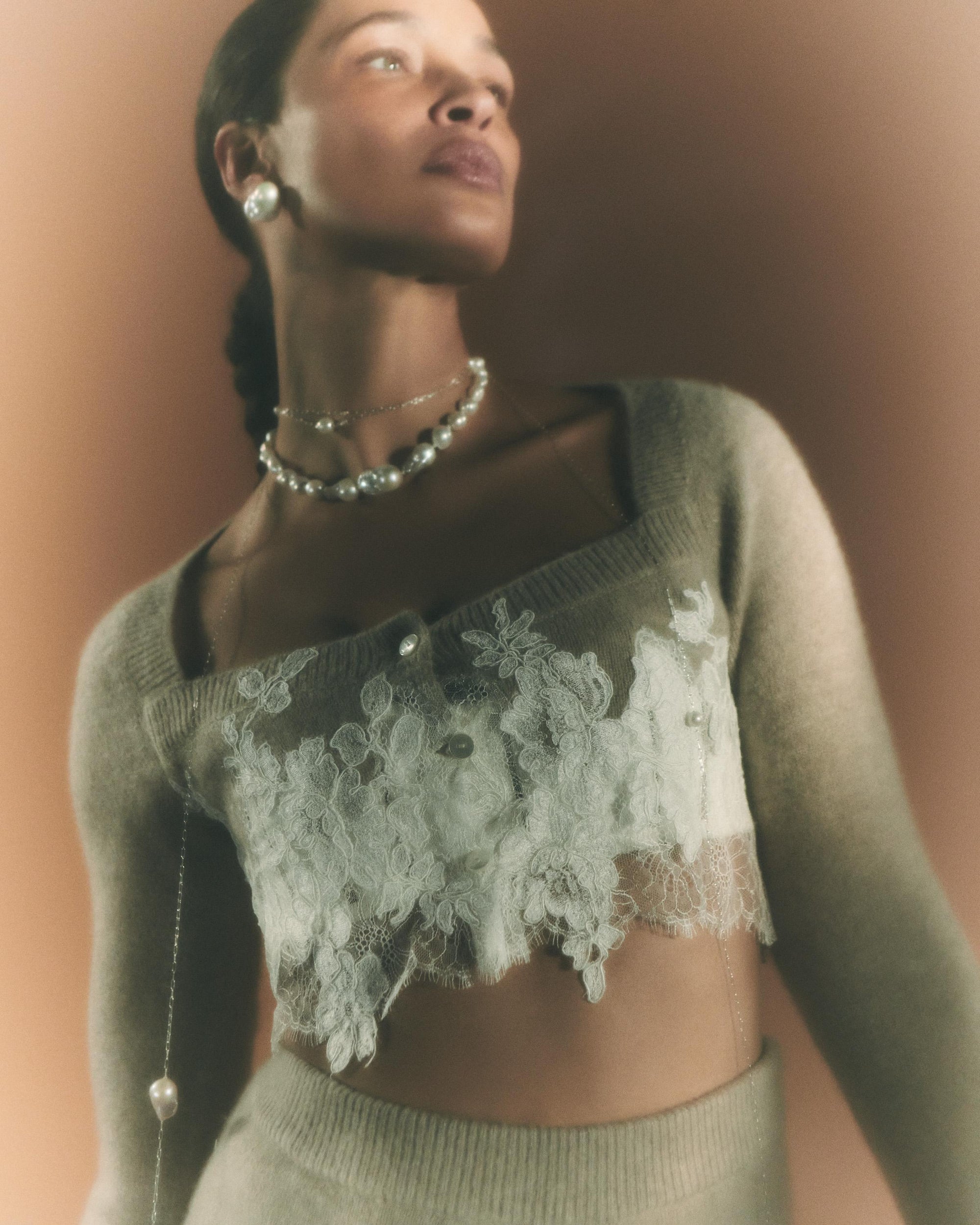 Silk cashmere cropped cardigan. Hand appliqued corded lace upon chantilly lace border at body. Three button close.