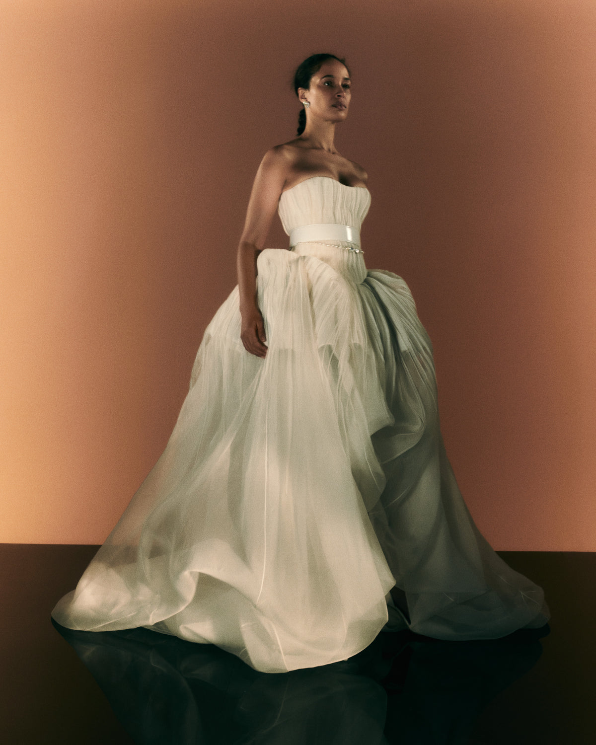 Silk organza strapless translucent ball gown with pintucked bodice. Basque waistline with soft sweetheart neckline. Sheer bubbled high-low skirt with extended train. Internal bustier with side boning and cups, grosgrain belt with 3 hook position. Center back zip close.The belt is sold separately.